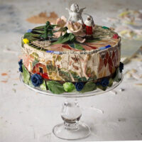 N.D. glass, ceramic and vintage Italian Majolica with antique lead toy soldier, bisque doll hands, ceramic angel, smalti and a Capodimonte Rose on vintage plate. 9 1/2 inches diameter, 4 inches tall, 13 inches tall on cake stand.
